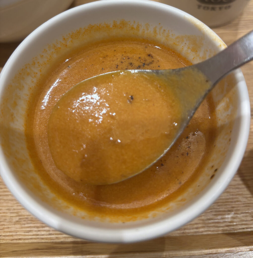 スープストックトーキョーの「オマール海老のビスク」を掬っている画像